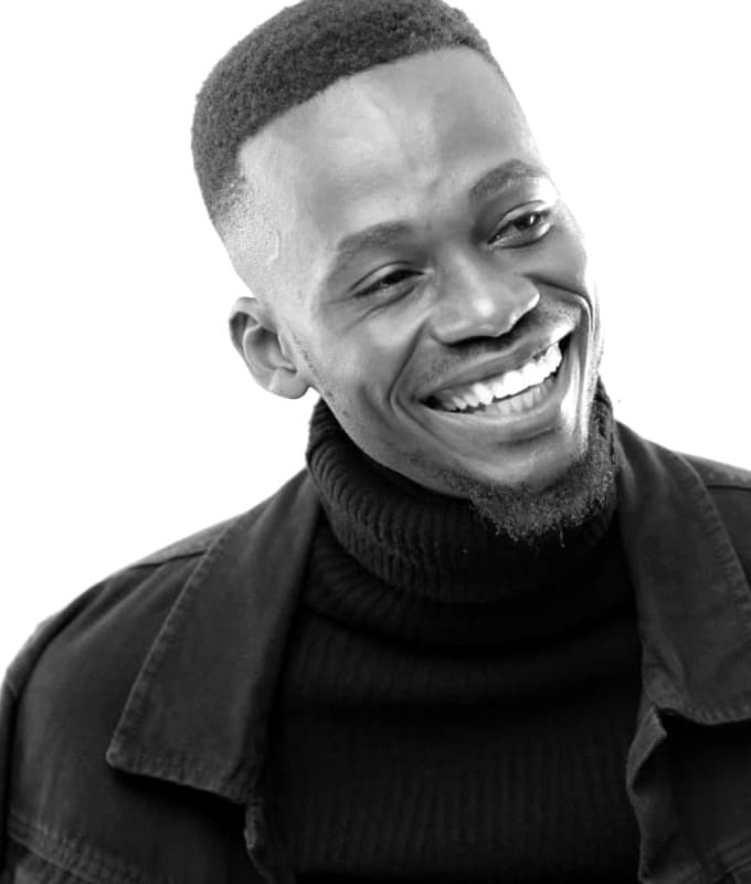 Ryan Synth smiling in a black turtleneck and jacket, black and white portrait